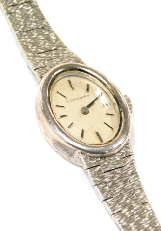 A Longines lady's silver cased wristwatch, oval silvered dial, seventeen jewelled movement, in an oval plain case, on a textured bracelet.