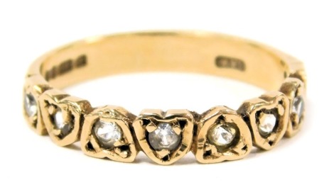 A 9ct gold and white stone half eternity ring, set with eight stones in a repeating heart shaped setting, size N, 2.0g.