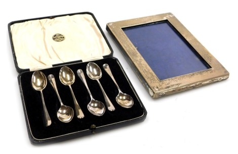 A set of six George V silver rat's tail coffee spoons, cased, London 1933, 1.32oz, together with a George V silver strut photograph frame, of rectangular plain form, Birmingham 1913.