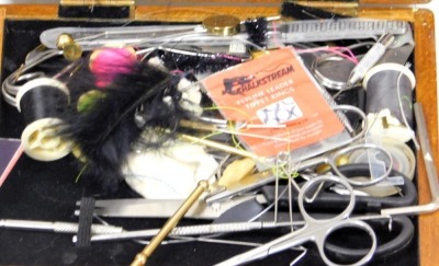 An assortment of fly tying equipment and materials, including a vice and collection of fly tying tools. - 2