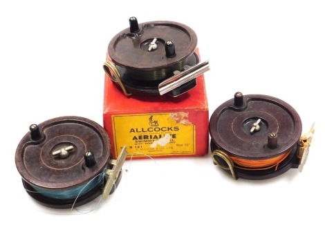 Three Allcocks Aerialite Bakelite centre pin reels, 9.5cm diameter, one lacking a line guard.