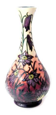 A Moorcroft pottery vase decorated in the Pasque Flower pattern, of bottle form, impressed marks and dated 2000, 31cm high, boxed.