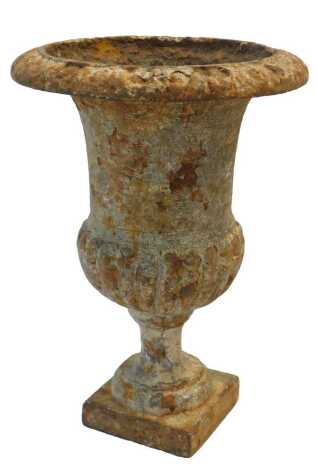 A 19thC cast iron urn, of semi-fluted form, raised on a square base, 22cm high.