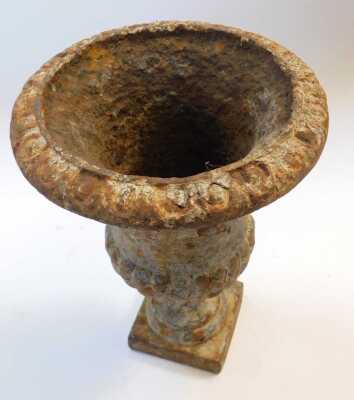 A 19thC cast iron urn, of semi-fluted form, raised on a square base, 22cm high. - 2