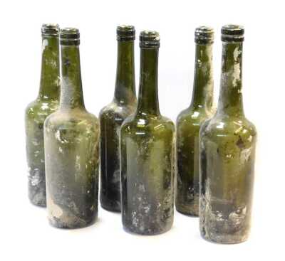 Six early 19thC green glass wine bottles, 30cm high.