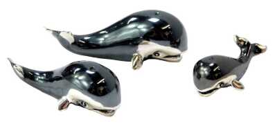 A graduated set of three silver figures modelled as whales, 5.5cm long, 4.5cm long and 3.5cm long.