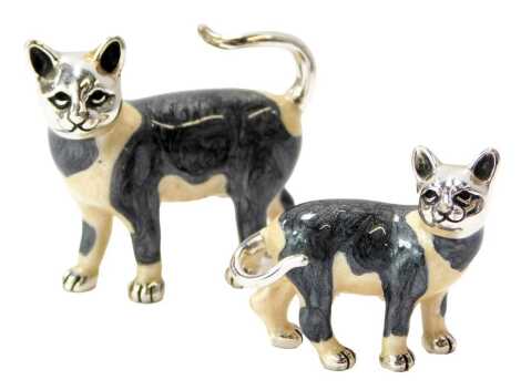 Two silver and enamel figures modelled as black and white cats, stamped 925, 4cm high and 2.7cm high.