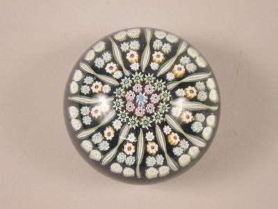 A Millefiori paperweight with various coloured canes on a predominately blue ground