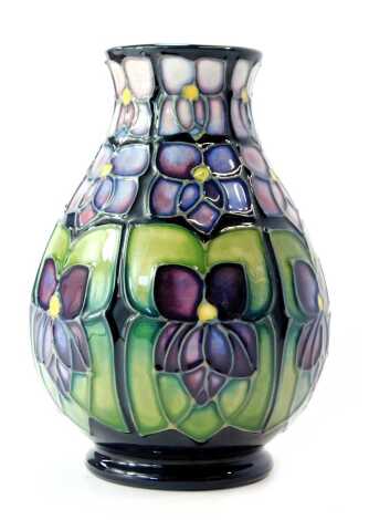 A Moorcroft pottery vase decorated in the Violet pattern, of baluster form, impressed marks and initialled KM, 14cm high, boxed.