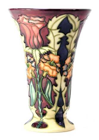 A Moorcroft pottery vase decorated in the Masquerade pattern, of trumpet form, impressed marks and dated 2000, 15cm high, boxed.