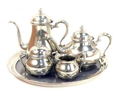 A Towle pewter four piece service, comprising teapot, hot water jug, lidded two handled sugar bowl and a milk jug, together with a circular tray, inset with a smoked glass panel, the tray 42cm diameter, touch marks present.