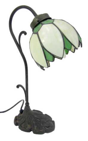 A Tiffany style table lamp, with a petallated milk glass and green shade, on shaped stem and on a rose cast shaped base, 39cm high.