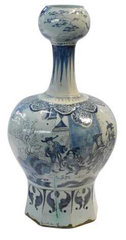 An early 18thC Dutch delft ware blue and white vase, with a garlic neck and an octagonal faceted bulbous body, chinoiserie decorated with warriors, and figures in a garden, 46cm high, (AF)