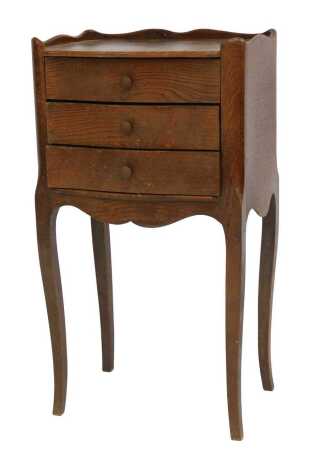 An early 20thC French oak bedside chest, of three drawers, raised on slender cabriole legs, 66cm high, 37cm wide, 29cm deep.