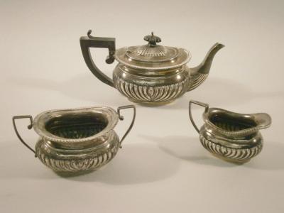 An associated silver three piece part fluted tea service