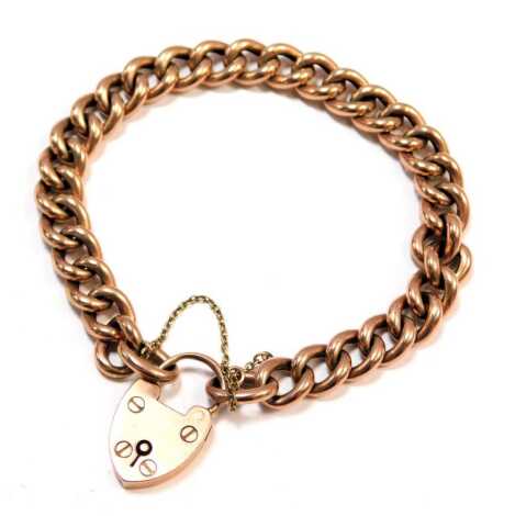 A rose gold charm bracelet, the curb link bracelet with heart shaped padlock and safety chain, yellow metal stamped 9ct, 20cm long, 18.1g.