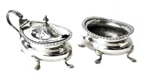 An Edward VII silver lidded mustard pot and open salt, each with a gadrooned border, initial engraved, raised on four lion paw feet, Birmingham 1902, 4.65oz.