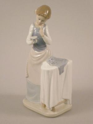 A Lladro porcelain figure of a lady with an iron and an ironing board