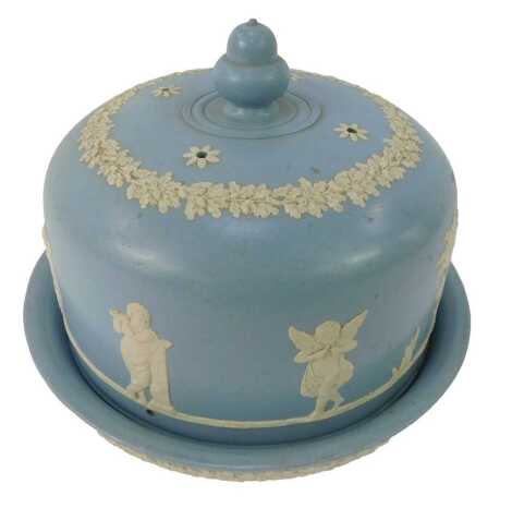 A late 19thC/early 20thC pottery cheese dome and cover, decorated in the style of Wedgwood, with raised figural, leaf and floral decoration against a blue glaze, 19cm high.