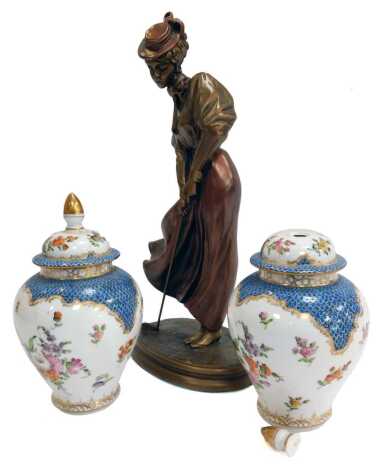 A pair of 20thC Dresden jars and covers, each decorated with flowers against a half blue scale and white ground, gilt heightened, 18cm high. (AF), together with an Austin resin figure of a female golfer in Edwardian attire, 34cm high. (3)