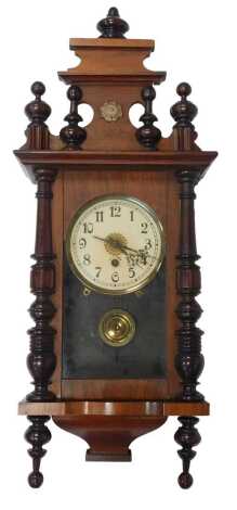 A Vienna walnut cased wall clock, the cream circular enamel dial bearing Arabic numerals, thirty hour, with key and pendulum, the case 67cm high.