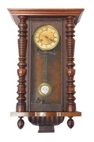 A Vienna walnut cased wall clock, the circular dial bearing Arabic numerals, eight day, the case with turned pilasters, with pendulum, the case 68cm high. (AF)