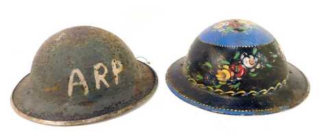 Two military helmets, one later painted with flowers.