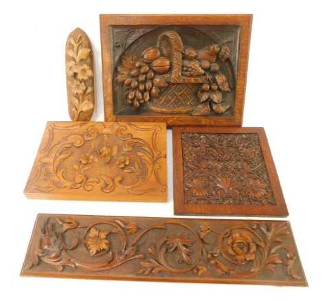 Three carved wooden panels, one depicting fruit in a basket, 30cm x 22.5cm, scrolls and flowers, with figural mythical beast, 45cm x 11cm, and a floral and scroll panel, 20cm x 20cm, a carved floral wall hanging, 22cm high, and a further scroll work and f