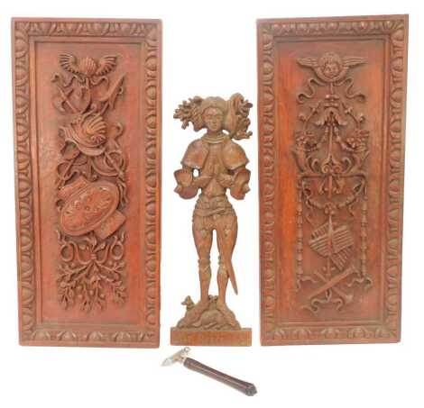 Two 20thC carved wooden panels, one depicting hunting motifs, with bust of cherub, floral and scroll work decoration, 62cm x 28cm, the other carved with shields, helmet, weaponry, etc, together with a carving of Sir Roger Lyon, 48cm high, and an ice break