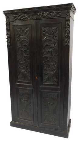 A Victorian oak wardrobe, the out swept pediment over a pair of foliate and griffin carved panelled doors, opening to reveal a vacant interior with later added pine shelves, raised on a plinth base, 198cm high, 105cm wide, 43cm deep.