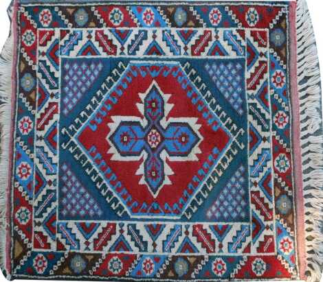 A Turkish red ground rug, with central medallion within multiple borders, 92cm x 94cm.