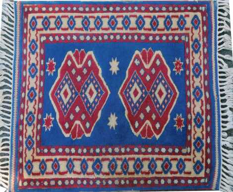 A Turkish blue ground rug, with two central medallions within one wide and two narrow borders, 84cm x 90cm.