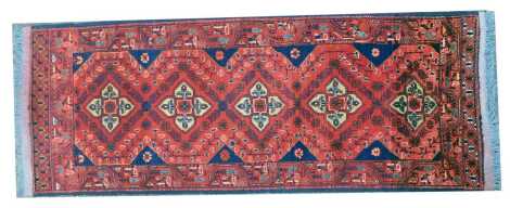 A Turkoman red ground rug, with five medallions within one wide border, 144cm x 56cm.