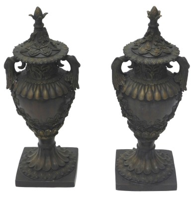 A pair of bronze two handled urns and covers, each cast with acanthus, grapes and vines, etc., on fluted column and square base, 66cm high.