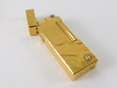 A Dunhill gold plated lighter, with engine turned and textured finish, emblem to front, 6.5cm long. - 2