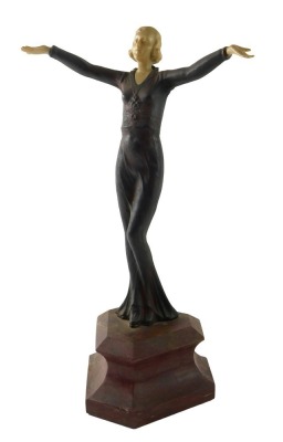 A resin Art Deco style figure of a dancer, on a simulated marble base, 36cm high.