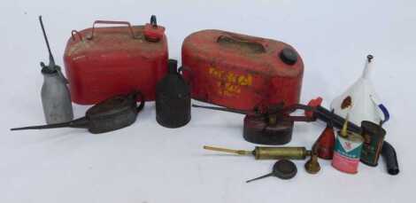 Two ready-can fuel cans, in red, together with various oil dispensers, enamel funnel, etc.