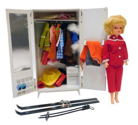 A Sindy doll, together with a wardrobe, containing various clothing and accessories, to include suede effect coat, various dresses, shoes, rain hat, etc., the wardrobe 32cm high.