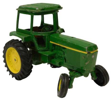 A John Deere tinplate tractor, in green, 18.5cm high.