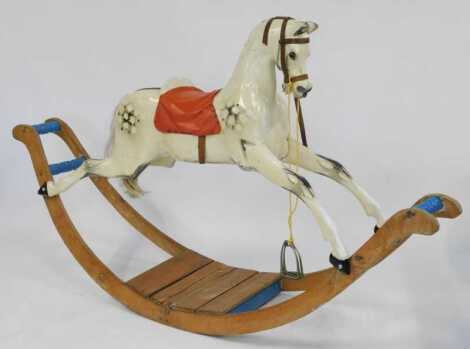 A Victorian dapple grey rocking horse, repainted, on pine base, lacking mane, 195cm long.