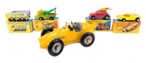 A Schuco Grand Prix Racer tinplate car, 1070, in yellow, together with four Matchbox cars comprising an eight wheel tipper, a Flying Bug, Toe Joe and one Mod Rod.