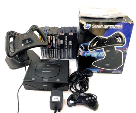 A Sega Saturn console, games and accessories, including Sega Saturn steering wheel, controllers, Fifa Road to World Cup, Nascar 98, NHL 98, Mortal Kombat 2, Euro 96, etc. (a quantity)