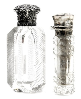 Two Victorian silver lidded scent bottles, comprising a cut glass and silver topped scent bottle, with rubbed marks, 10cm high, and a further example, 7cm high. (2)