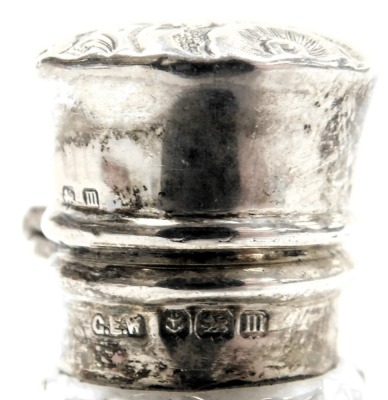 Two Victorian silver lidded scent bottles, comprising a cut glass and silver topped scent bottle, with rubbed marks, 10cm high, and a further example, 7cm high. (2) - 2