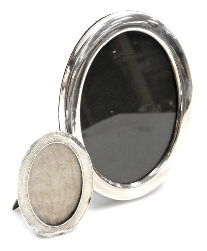 Two silver oval photograph frames, comprising a coloured small example, Birmingham 1922, 7cm x 9cm, and a H M silver oval photograph frame, 16cm x 13cm, maker F H, Sheffield 1986. (2)