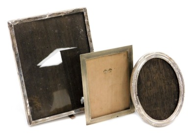 Three various photograph frames, comprising a rectangular white metal photograph frame, 22cm x 17cm stamped 925, an oval frame, white metal with rubbed hallmarks, 16cm x 12cm and an early 20thC silver plated rectangular photograph frame. (3)