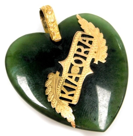 A jade heart shaped pendant, with applied "Kia-Ora" crest, with yellow metal mounts, unmarked, 3.5cm high, 11g all in.