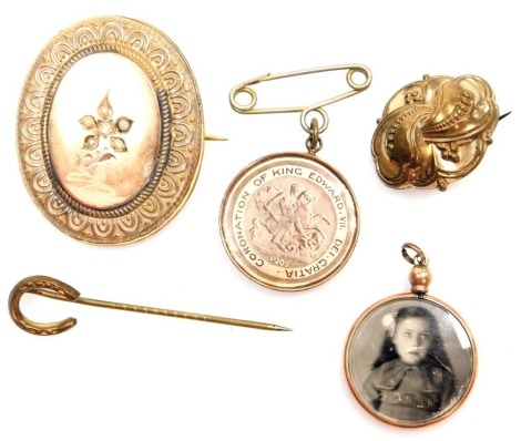 A group of Victorian and later jewellery, comprising an oval brooch, with floral border and applied seed pearls, on single pin back, 4cm high, crossover brooch, 3cm wide, two pendants and a horseshoe pin, mainly plated. (5)