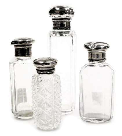 Four cut glass and silver topped scent bottles, one with pressed glass decoration, the largest 15cm high. (4, AF)