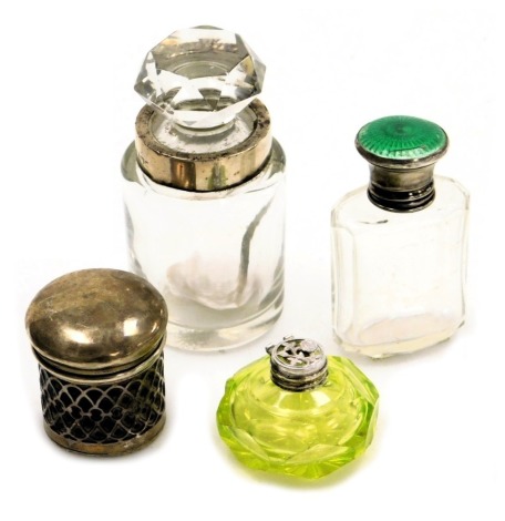 Four silver and cut glass scent bottles, comprising a Victorian green enamel top and cut glass scent bottle, decanter and stopper, lined glass scent bottle, and a pierced floral style and green glass scent. (4)